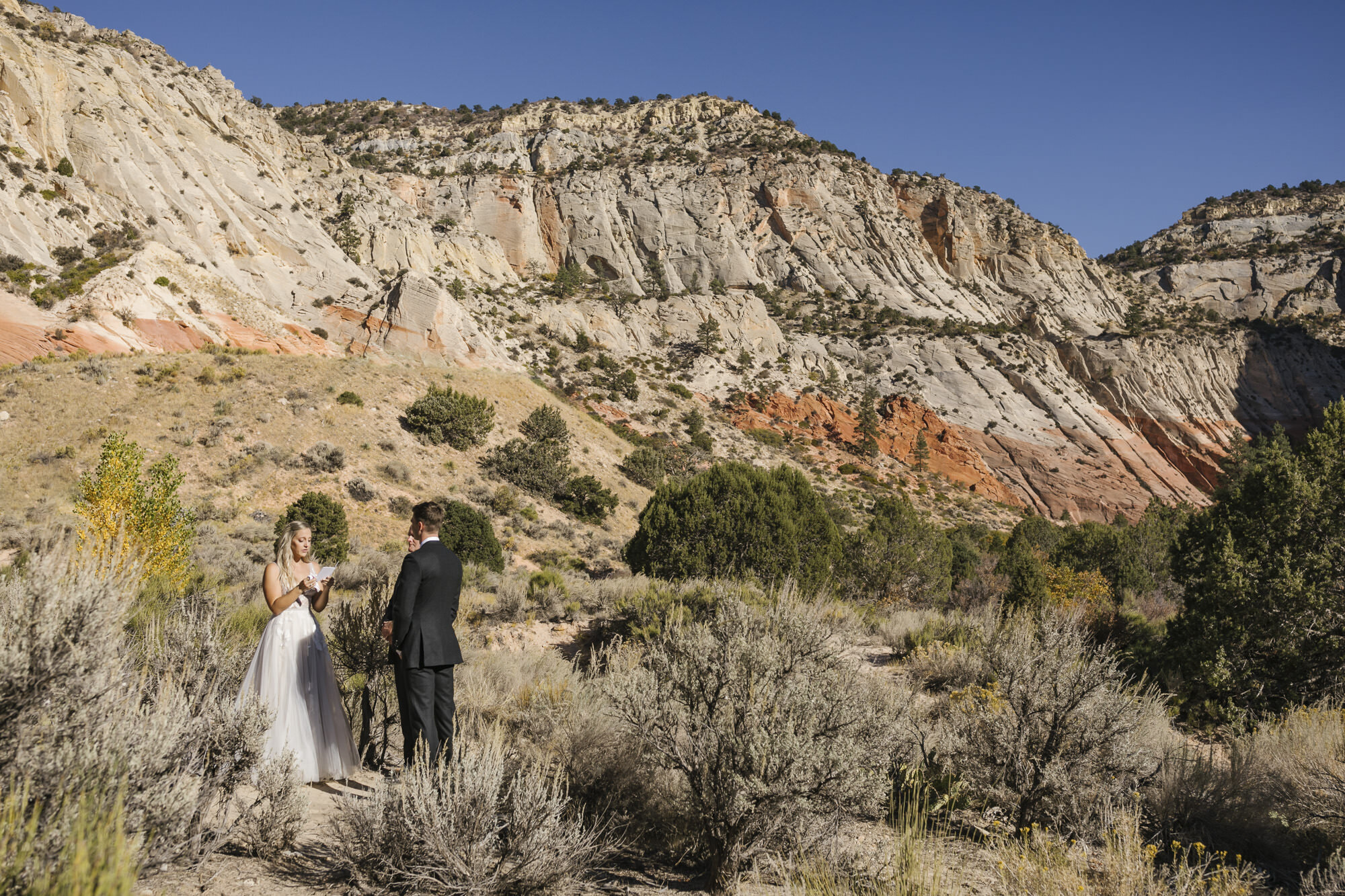 Bride and groom exchange wedding vows at an epic canyon location in the Utah desert