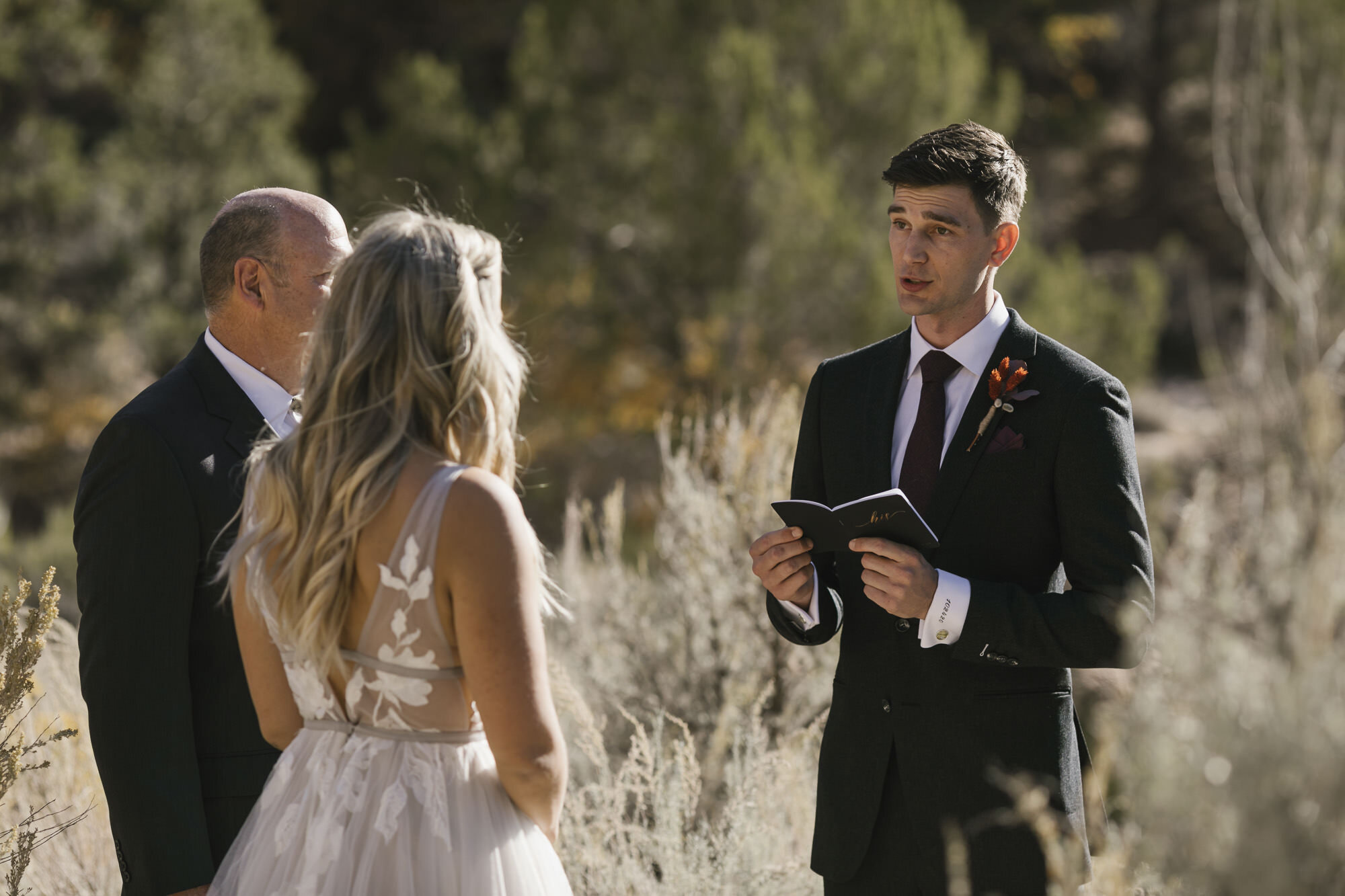 Groom reads his vows to his bride in the desert in Utah