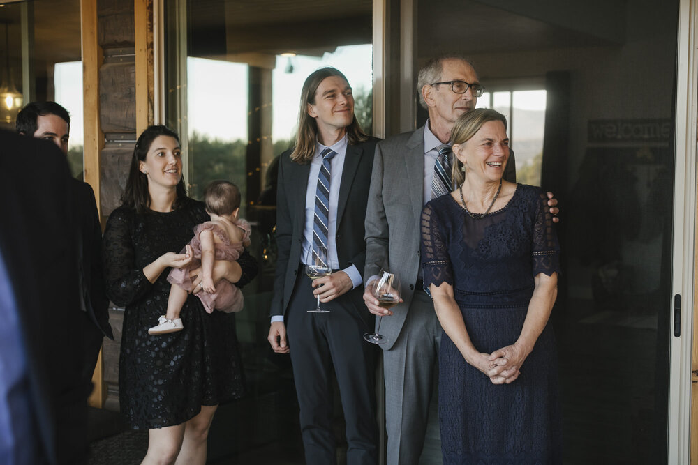 Groom's family happily watches the bride and groom's first dance