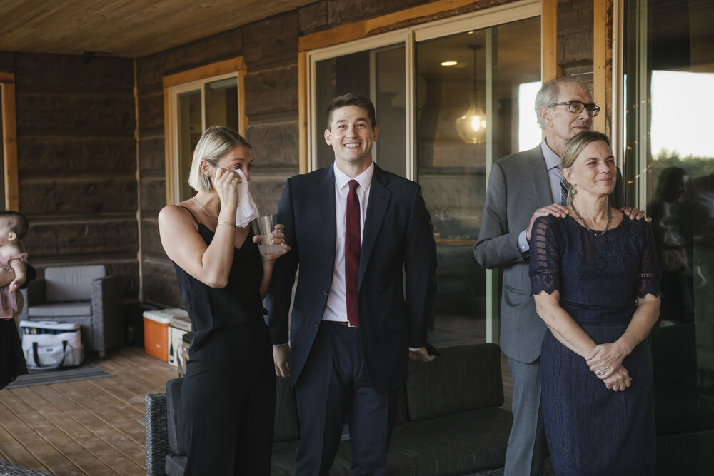 Bride's sister wipes tears as she watches her sister dance with their dad