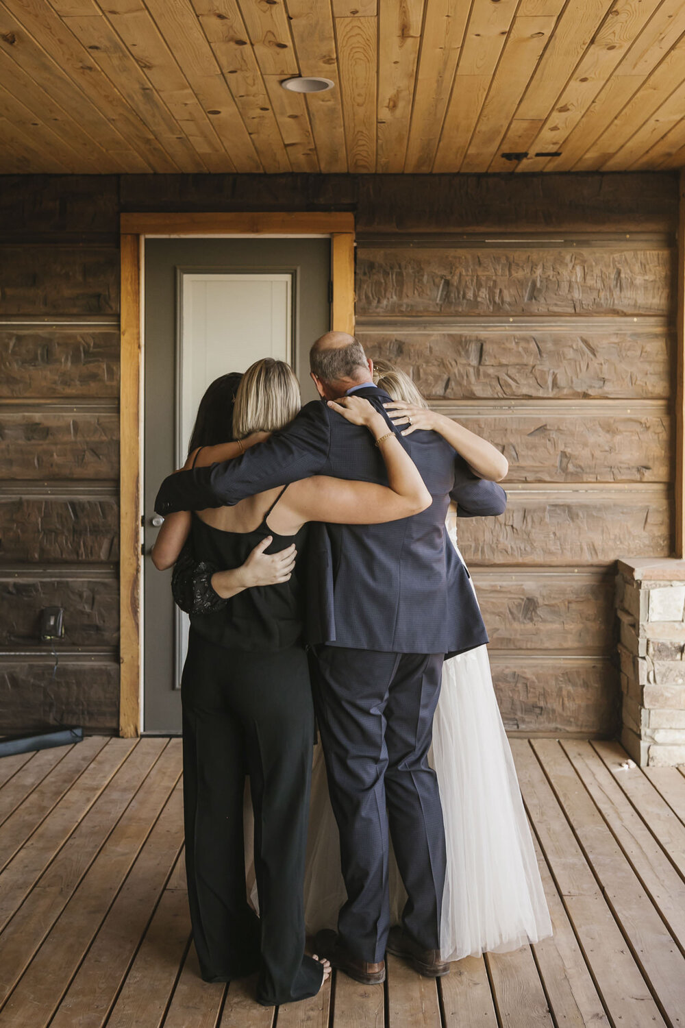 Bride's family dances together in a circle, their arms wrapped around each other