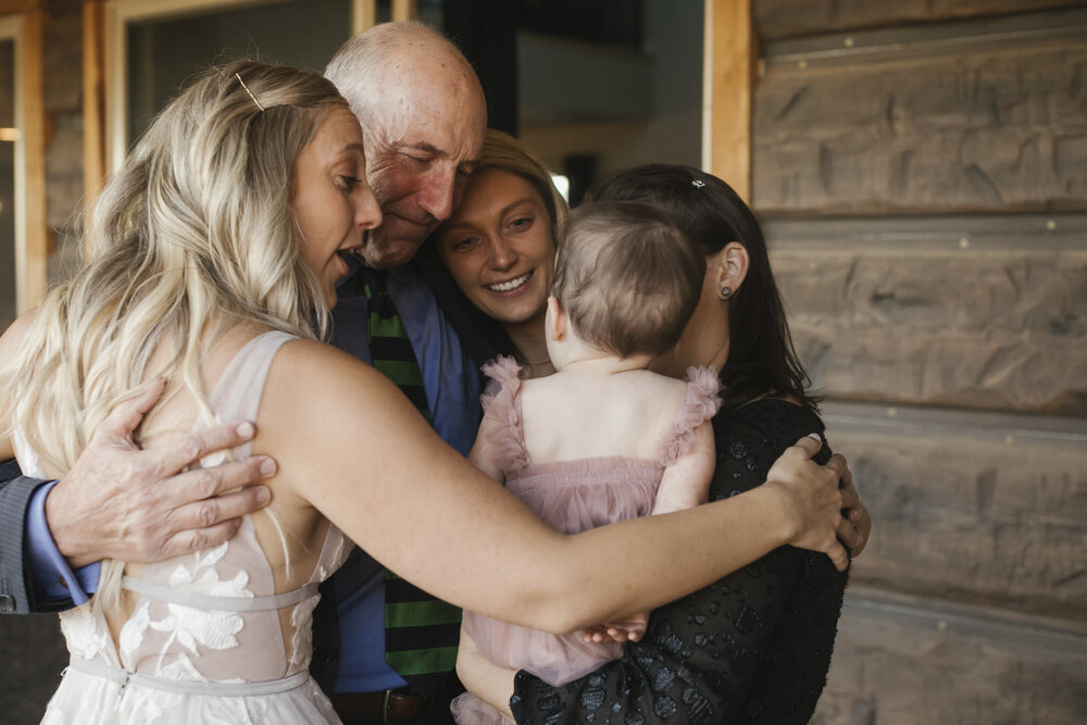 Bride's family dances together while looking fondly at their baby niece 