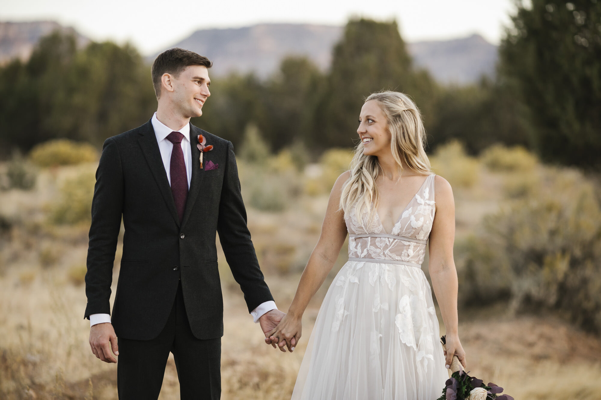 Just married couple hold hands during their Utah desert wedding
