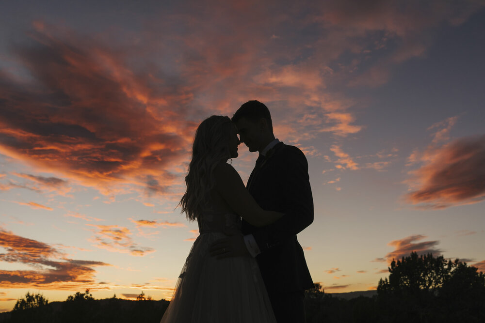 Silhouette of wedding couple in front of epic pink sunset outside of Zion in the Utah desert