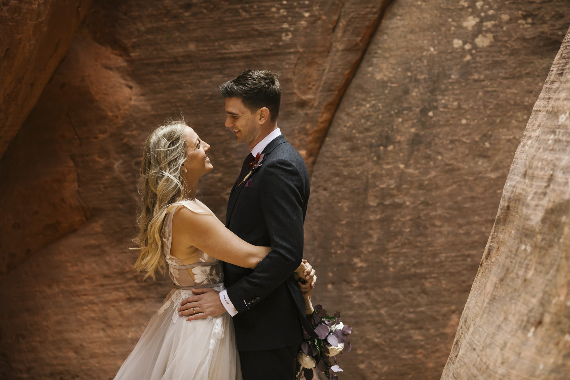 Bride and groom hug in a slot canyon in Utah