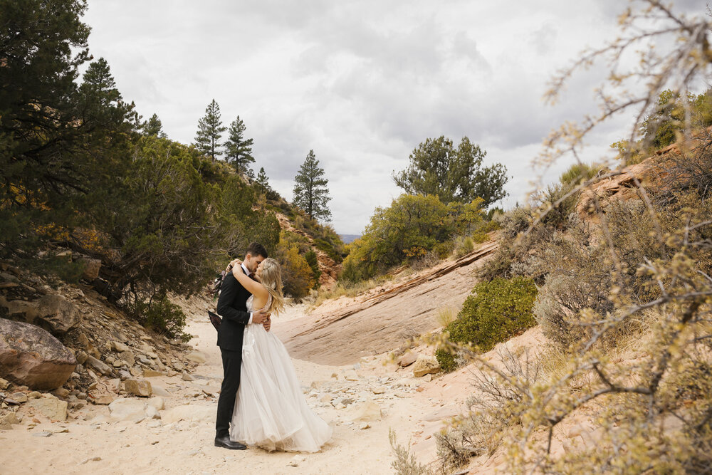 Couple kiss during their wedding portraits in the Utah desert