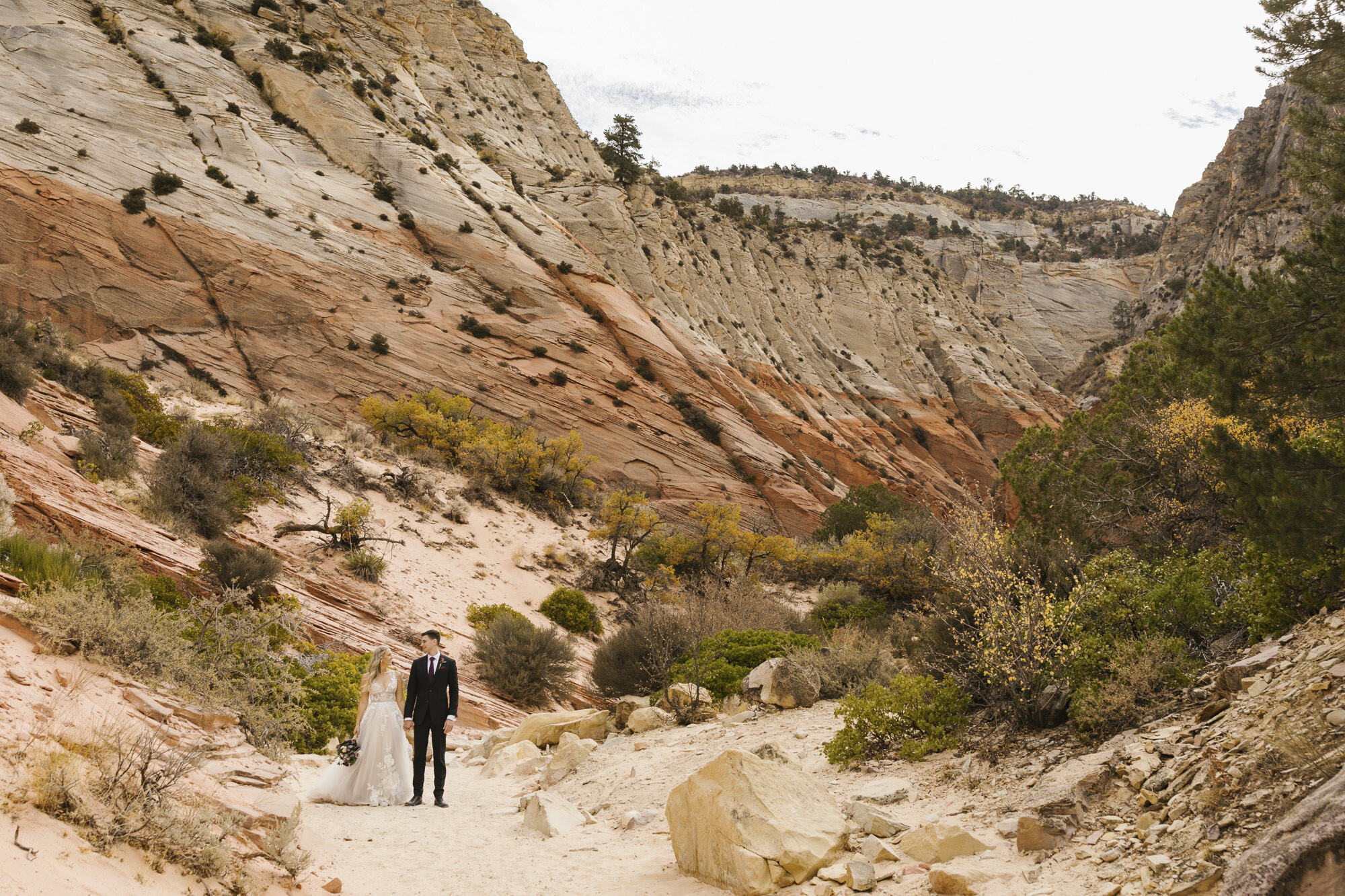 Wedding couple stand together in the Utah desert during their day-after portraits