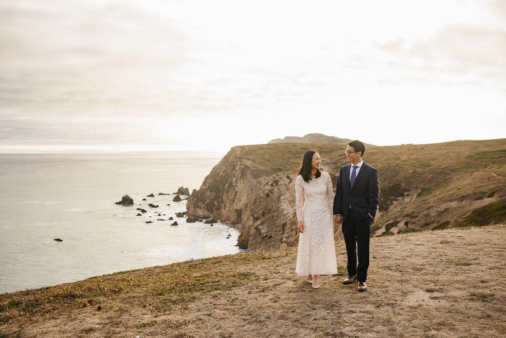Elopement couple walk together in Point Reyes overlooking the coast