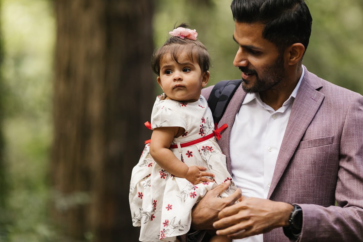 Cute little girl and her dad wait for ceremony to start at couple's redwood forest elopement