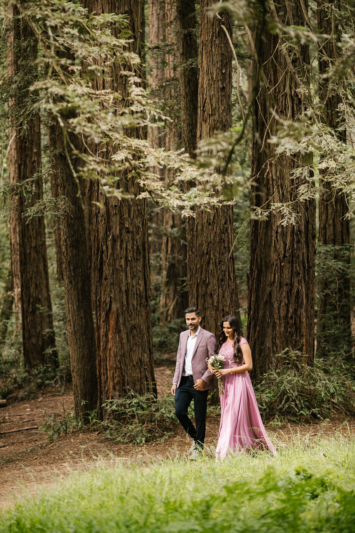 Bride walks through the redwoods to her forest elopement ceremony