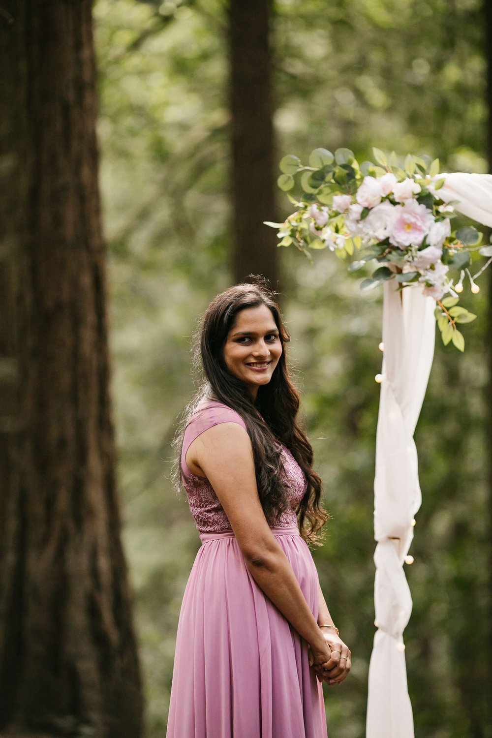 Bride smiles at guests during her redwood forest elopement