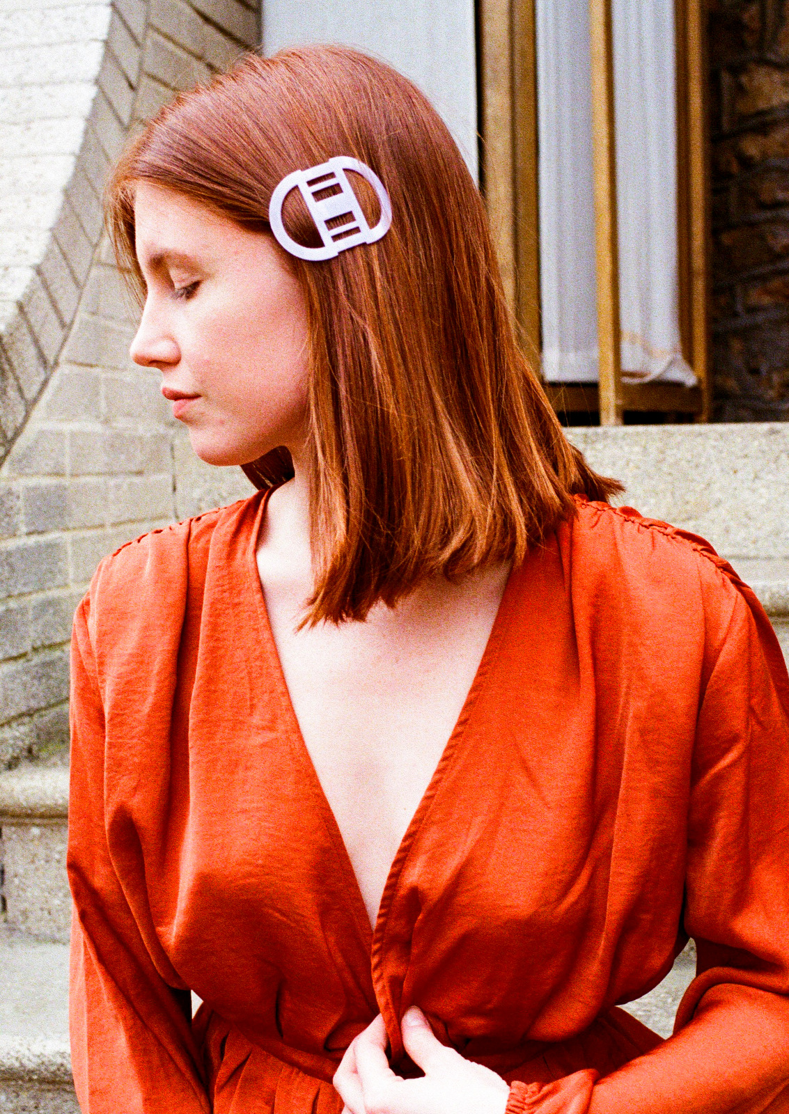 fille avec blouse cognac décolleté et barrette en résine blanche