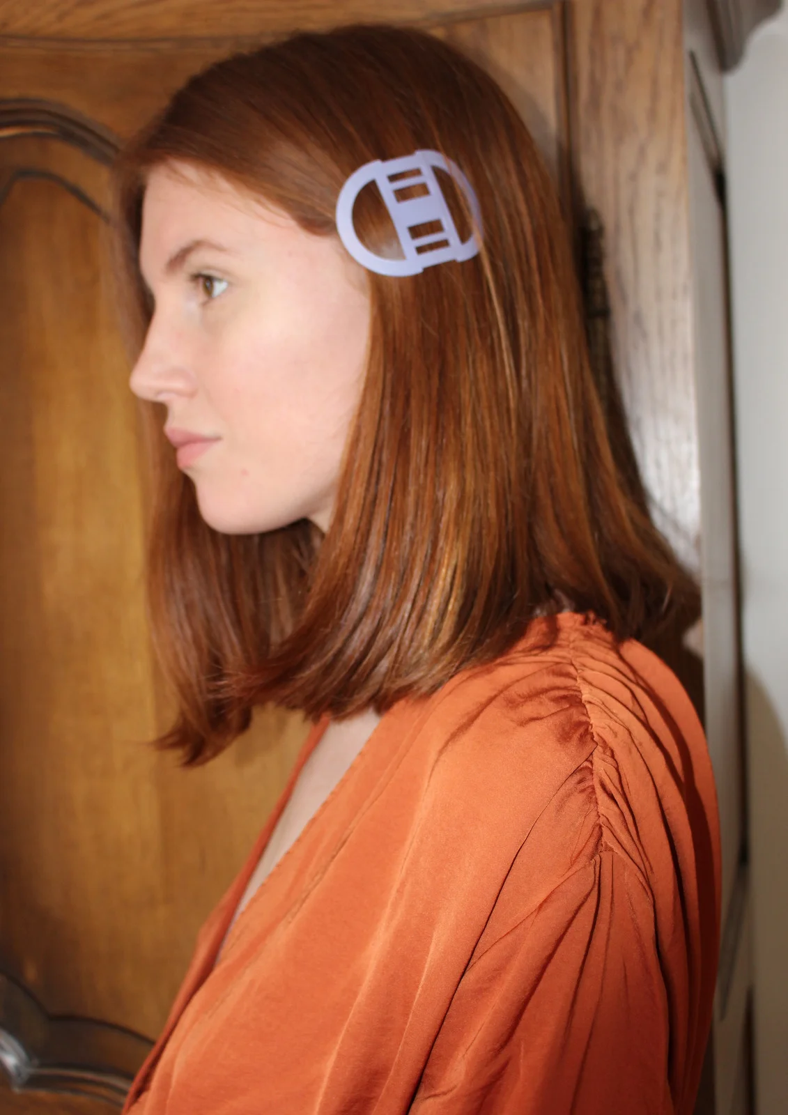 fille avec blouse orange et barrette blanche