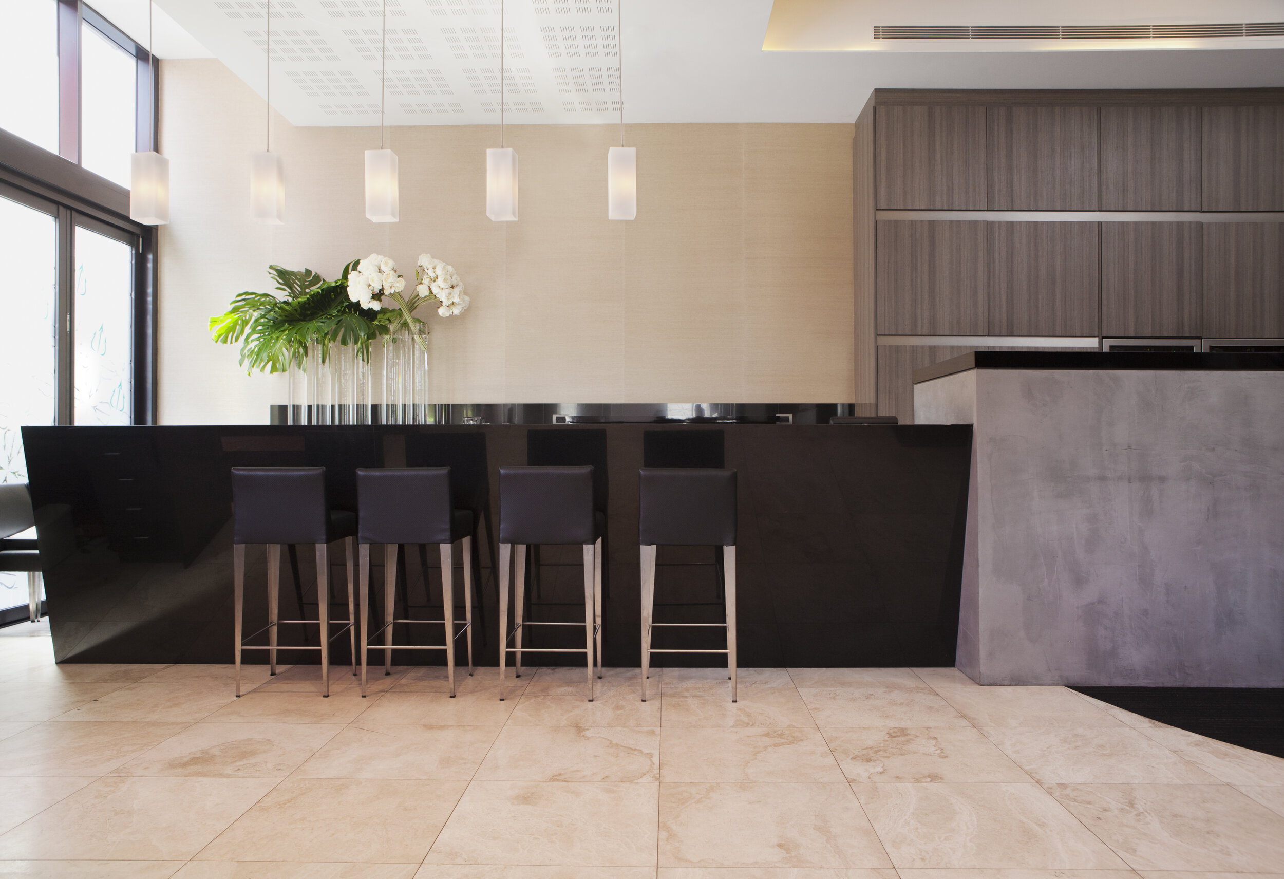 Contemporary kitchen with black stone island, bar seating and custom joinery by Luis La Pegna Designs Sydney