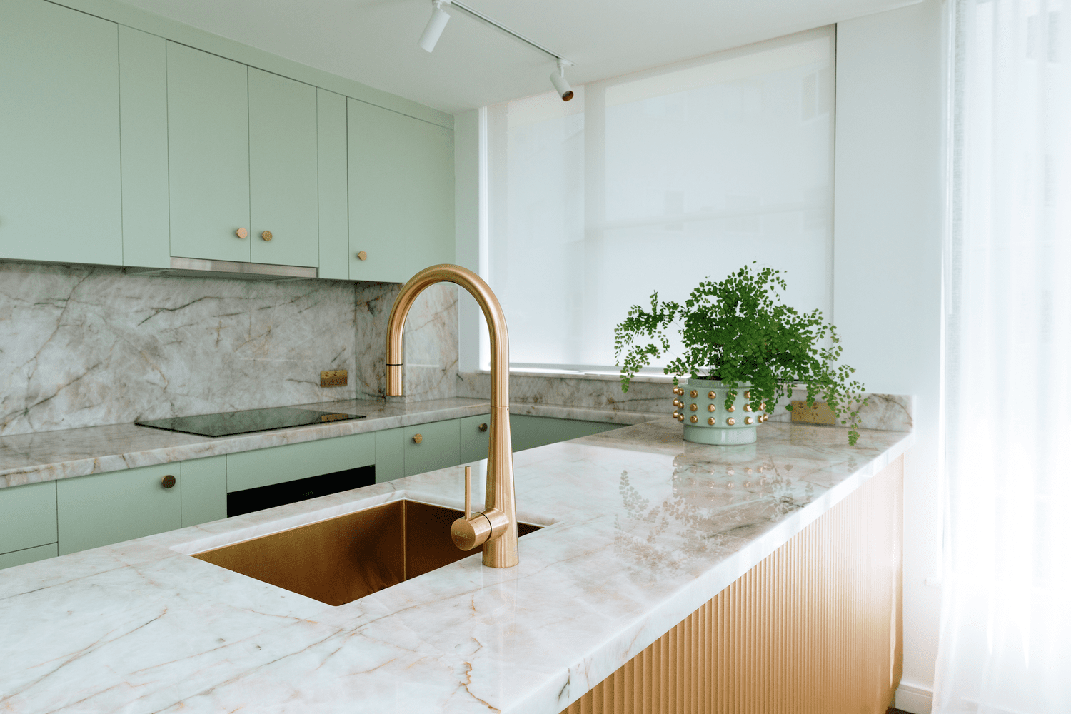 Onslow Residence sage green kitchen with a marble splashback