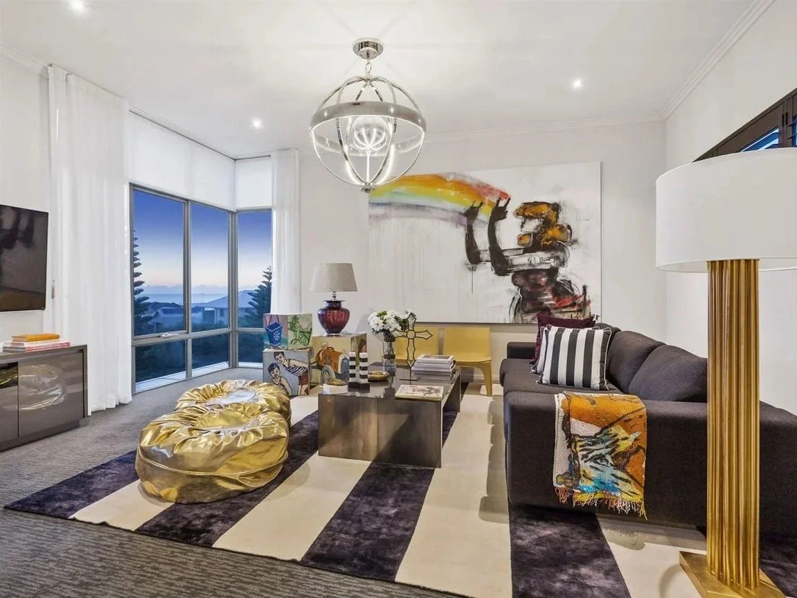 Luxury sitting room at Arabella Residence featuring bespoke furnishings, statement artwork, layered textures, designer lighting and expansive harbour views, creating a refined and contemporary living space by Luis La Pegna.