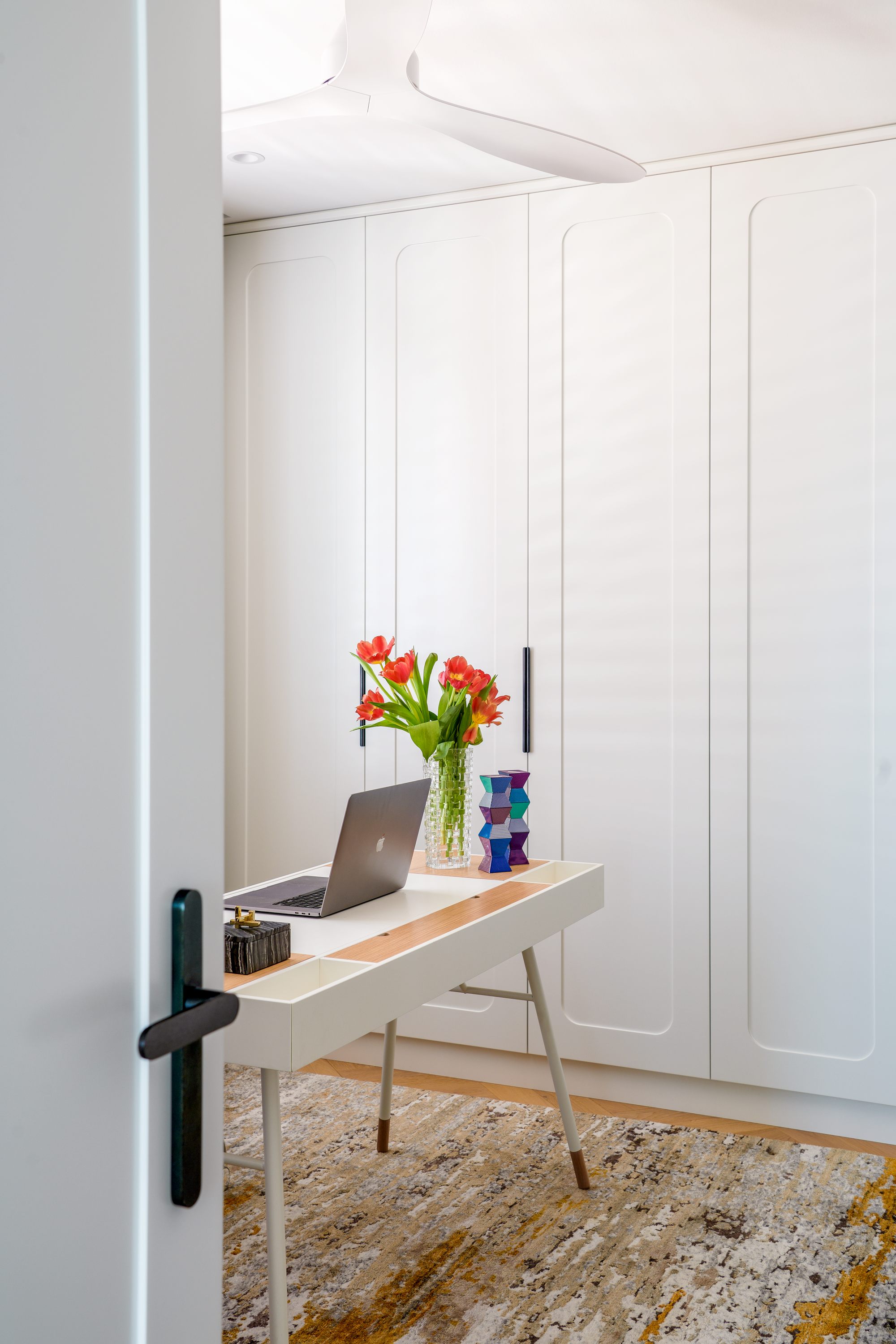 Home office with custom built-in storage, a minimalist desk and tailored cabinetry. Warm timber accents, contemporary styling and natural textures create a functional and inviting workspace designed for productivity and calm.