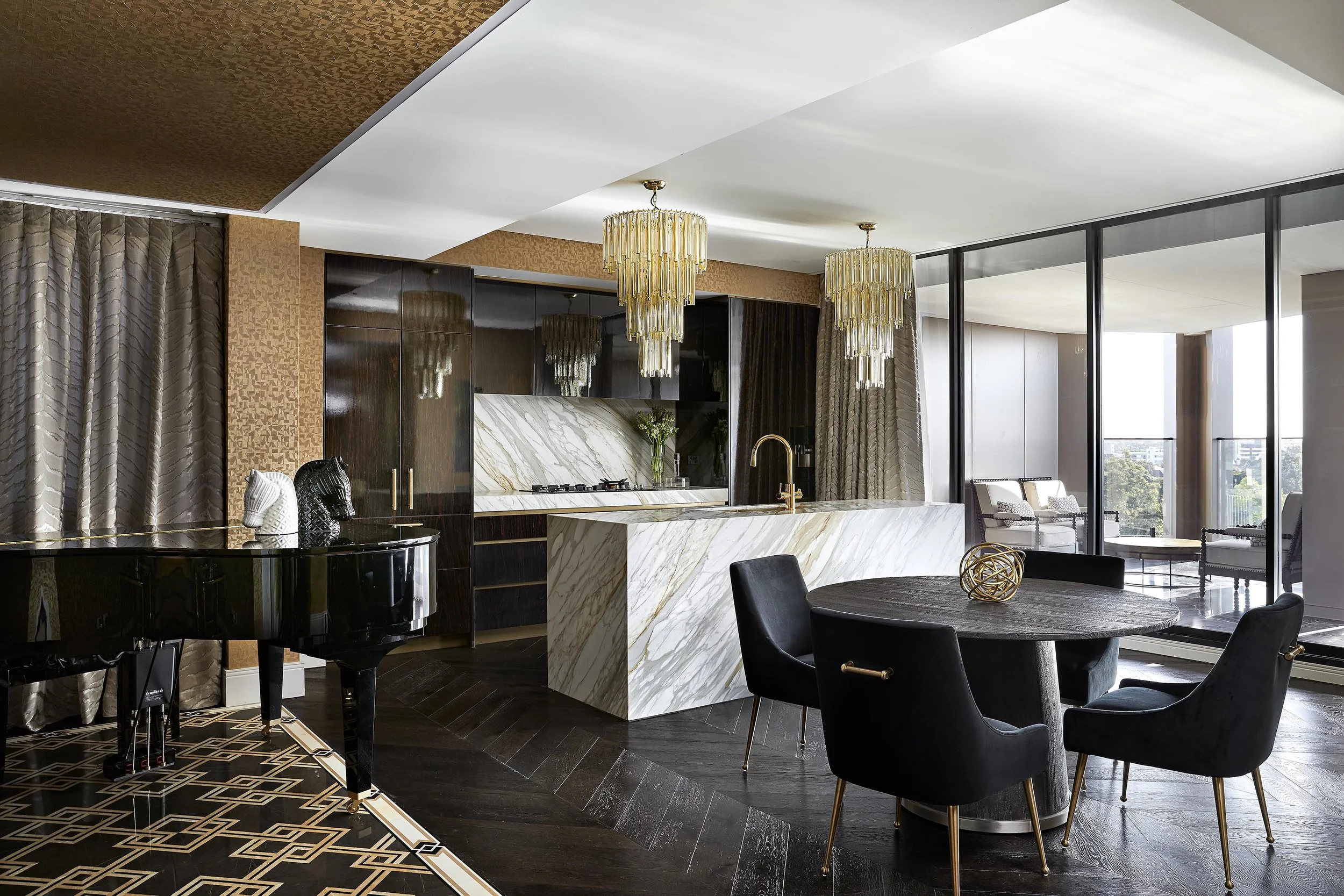 Burwood Residence penthouse kitchen and dining area with marble island, dark timber cabinetry, black dining setting, crystal pendant lights and grand piano.