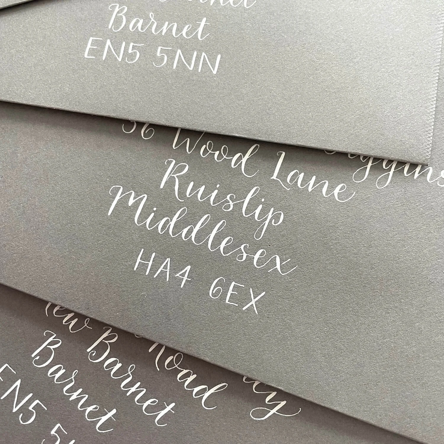 white hand lettering on coloured envelope north London address