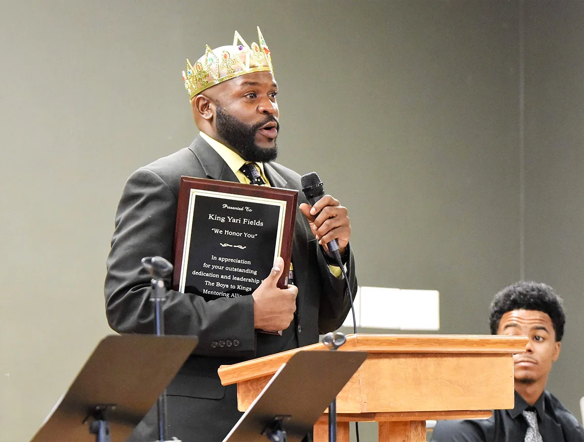 Boys to Kings Mentoring Alliance Director Kenyari Fields speaks at Saturday's event while holding a plaque presented to him by parents of some of the students. Photo by William 'Bud' Hardy / Neuse News