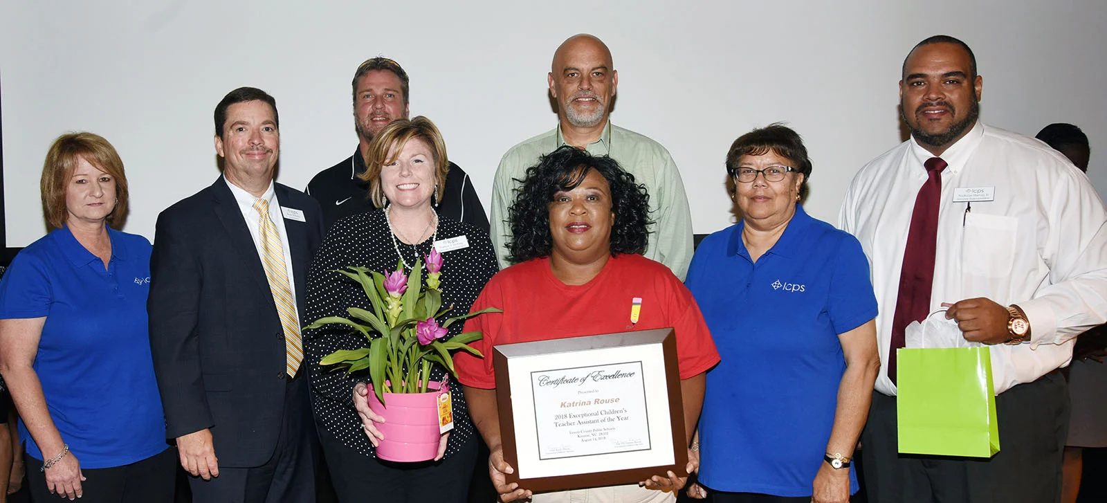 Katrina Rouse of North Lenoir High School, 2018 EC Teacher Assistant of the Year, is flanked by Associate Superintendent Frances Herring, left, and EC Department Director Vivian Roach. The back row is, from left, Julie Hill, EC Department assistant director; Superintendent Brent Williams; North Lenoir assistant principal Brian Yarbrough; North Lenoir principal Gil Respess; and Assistant Superintendent Nicholas Harvey II. Photo by Patrick Holmes / Lenoir County Public Schools