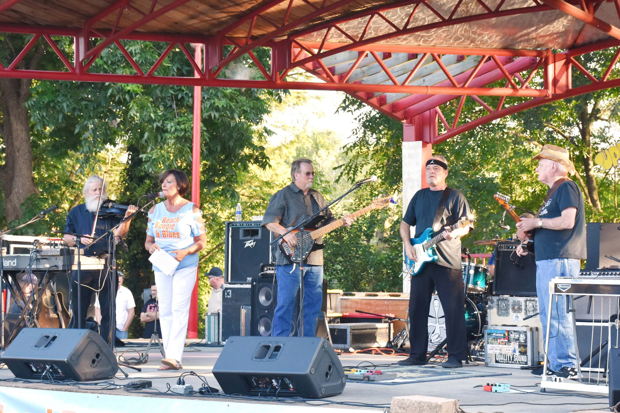 Curtis Media Group Account Executive Raine Tyndall, second from left, introduces the band and welcomes the crowd to the show.
