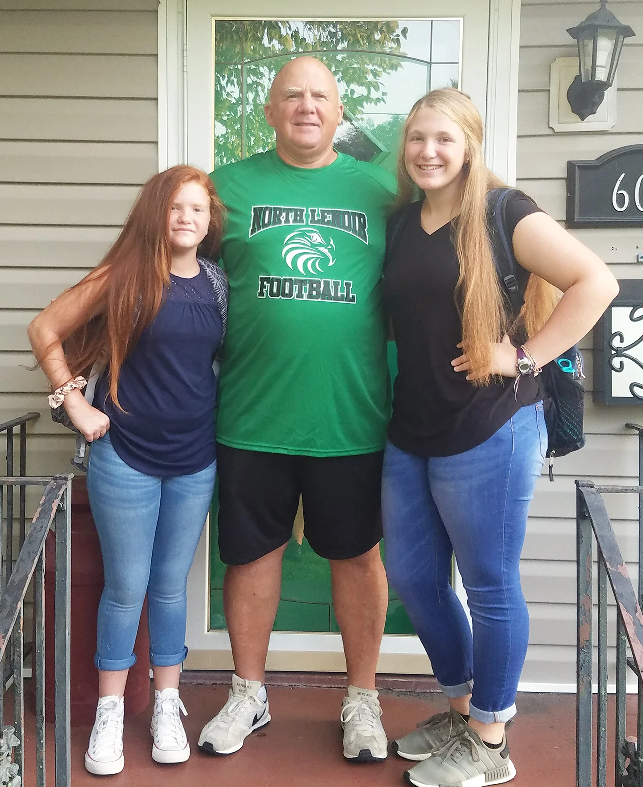 Faith Collins, left, eighth grade, Frink Middle School and Lark Collins, junior, North Lenoir High School pose with their father, Jim Collins, the first-year North Lenoir head football coach.