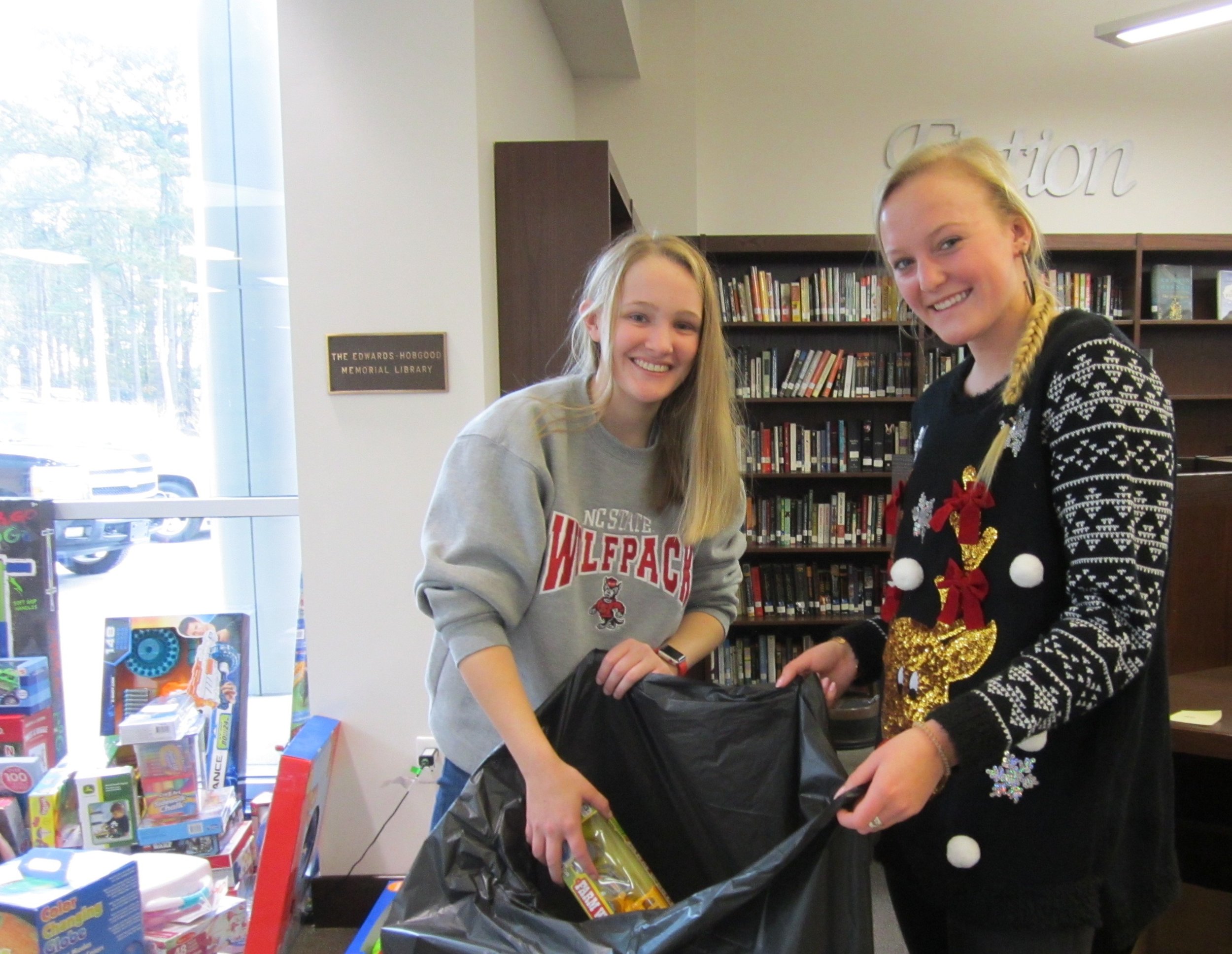 Reagan Perry and Megan Blair help load toys donated by Parrott students for the Salvation Army Christmas Cheer Giveaway.