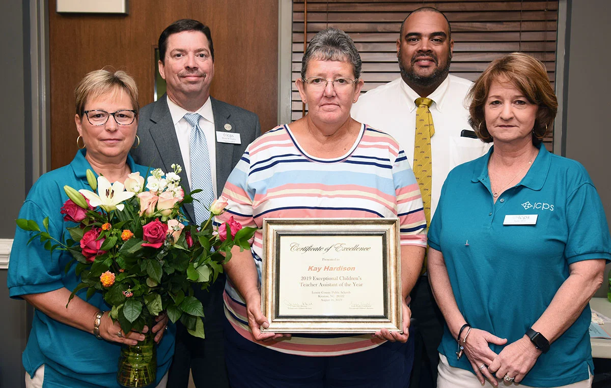 Kaye Hardison, center, of Northeast Elementary School was named an Exceptional Children Teacher Assistant of the Year for 2019-2020. Presenting her with the award are, from left, front, EC coordinator Lynn Heath and department director Julie Hill; back row, Superintendent Brent Williams and Assistant Superintendent Nicholas Harvey II.