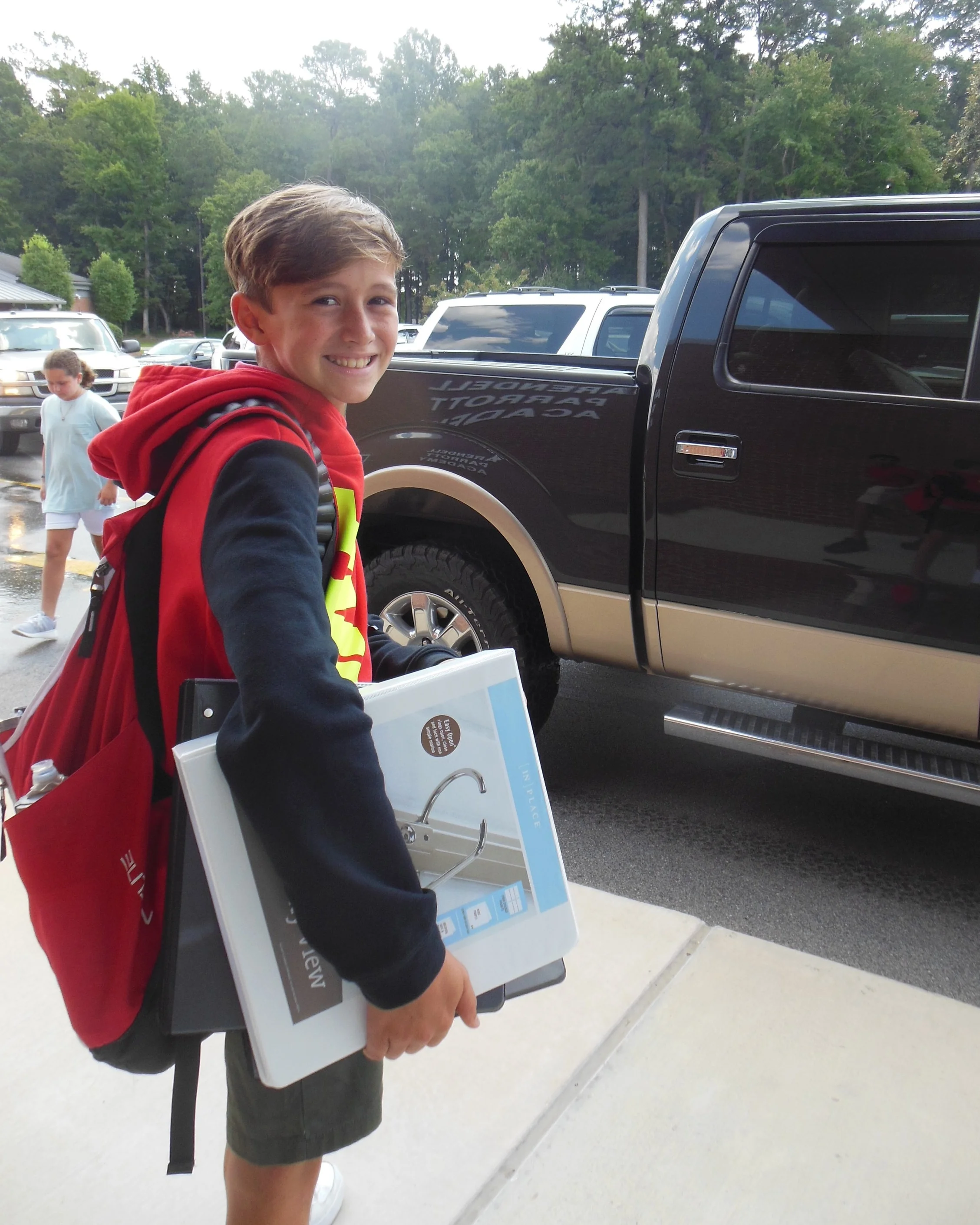 Ready to head home after his first day of middle school, 6th grader David Dunn waits to be picked up.