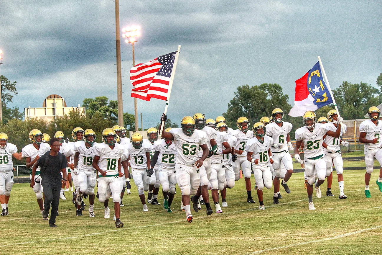 The Kinston Vikings, led by senior defensive lineman Walt Simmons (53) and senior receiver/defensive back Will London (23), run onto the field before Friday’s season-opener at Farmville Central. Photo by Linda Whittington / Neuse News