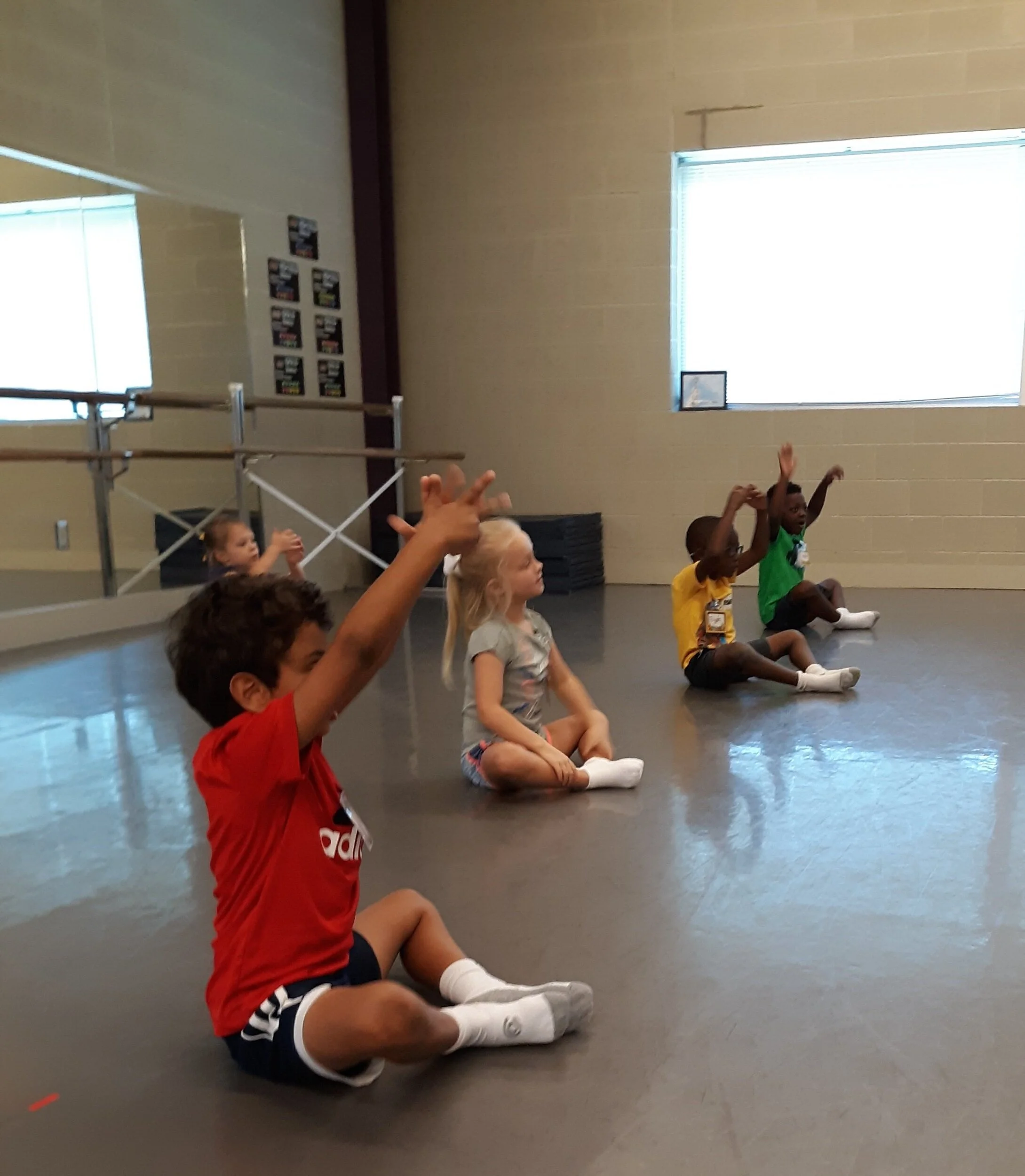 Matching motions to directions helps young learners focus. Left to right, front: Sherif Iskander, Lawson Stancill, Elijah Sparks, and Amare Mewborn. Back: Kalee Barfield.