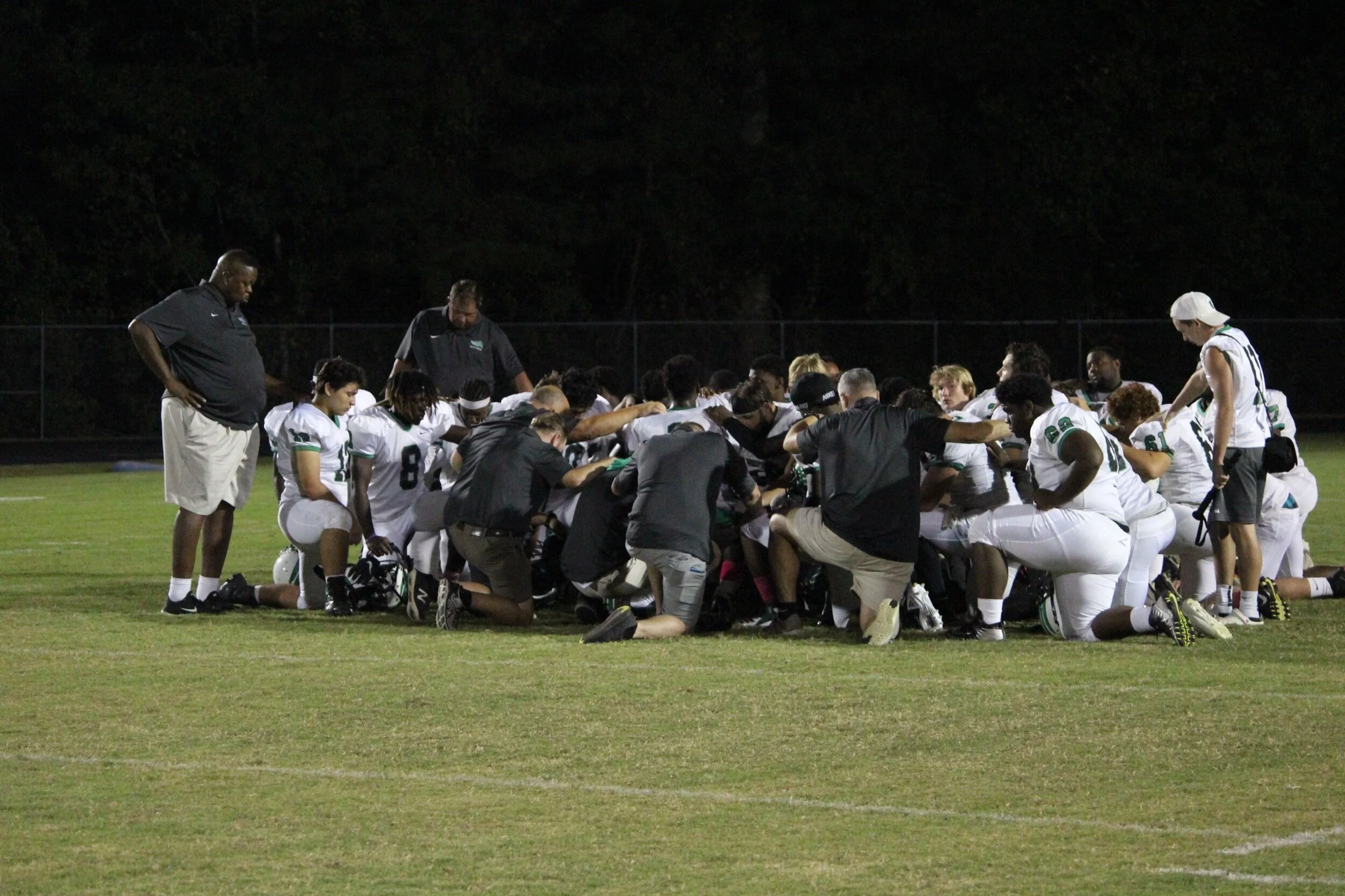 The North Lenoir Hawks football team says a postgame prayer after their 33-6 loss to Washington on Friday. Photo by Laieke Abebe / Neuse News