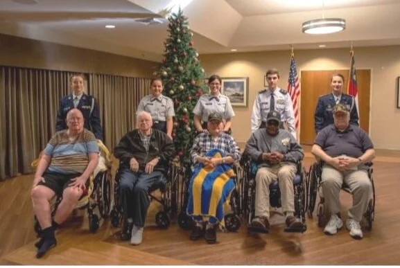 Cadets from Goldsboro Composite Squadron, Civil Air Patrol, pose for a photo with residents of the NC State Veterans Home in Kinston, NC. Back Row: C/MSgt Alona Arnette, C/Amn Ysabella Bylica, C/Amn Aliciana Bylica, C/1st Lt Benjamin Michael, C/Maj …