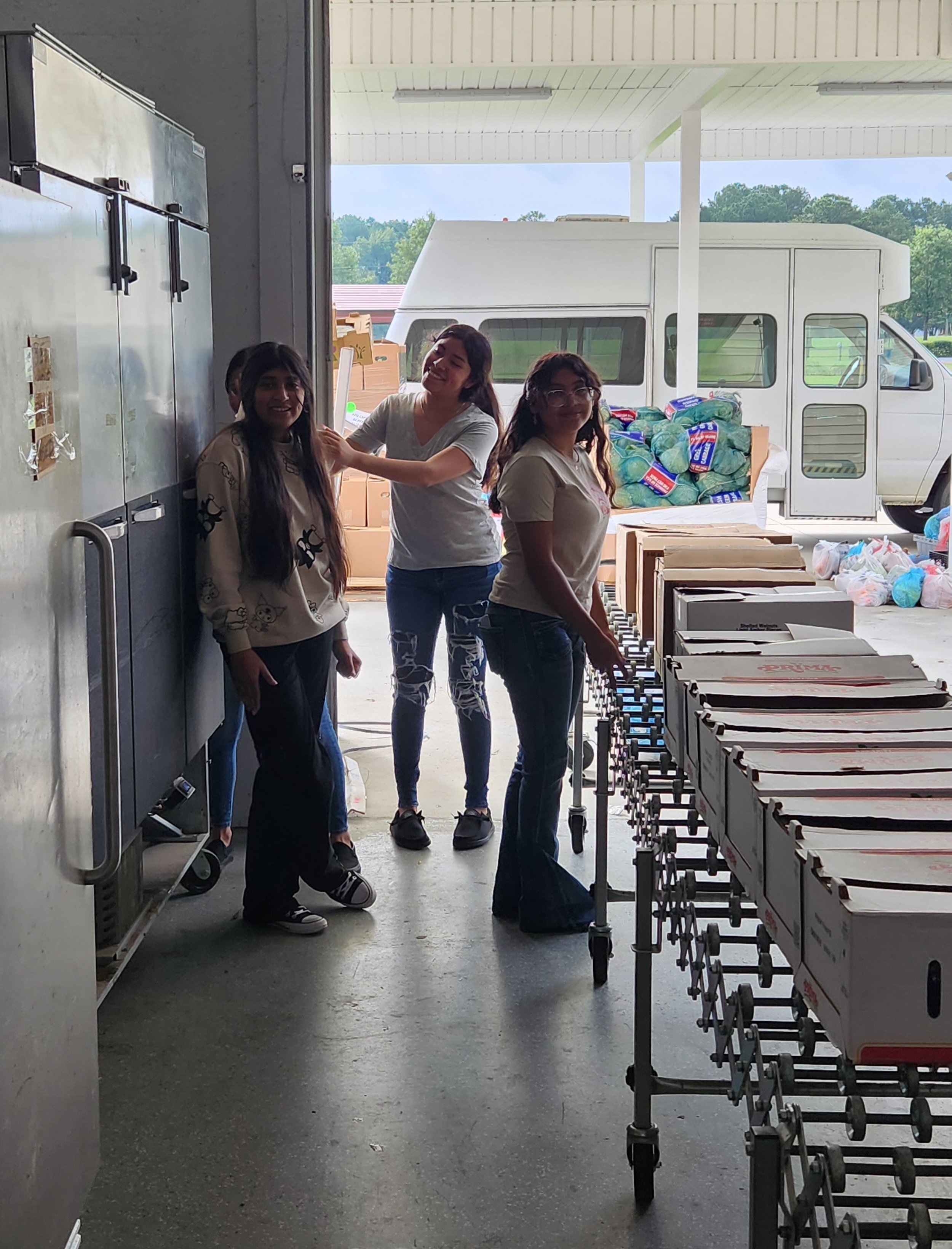  As boxes move down the conveyor belt, student volunteers from GEC packed them with fresh, canned, and frozen food&nbsp; item ready to be picked up. 