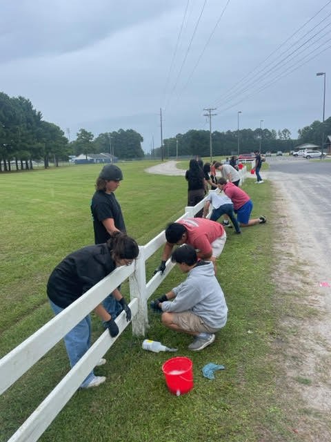 students cleaned the vinyl fencing at the entrance driveway to the campus.