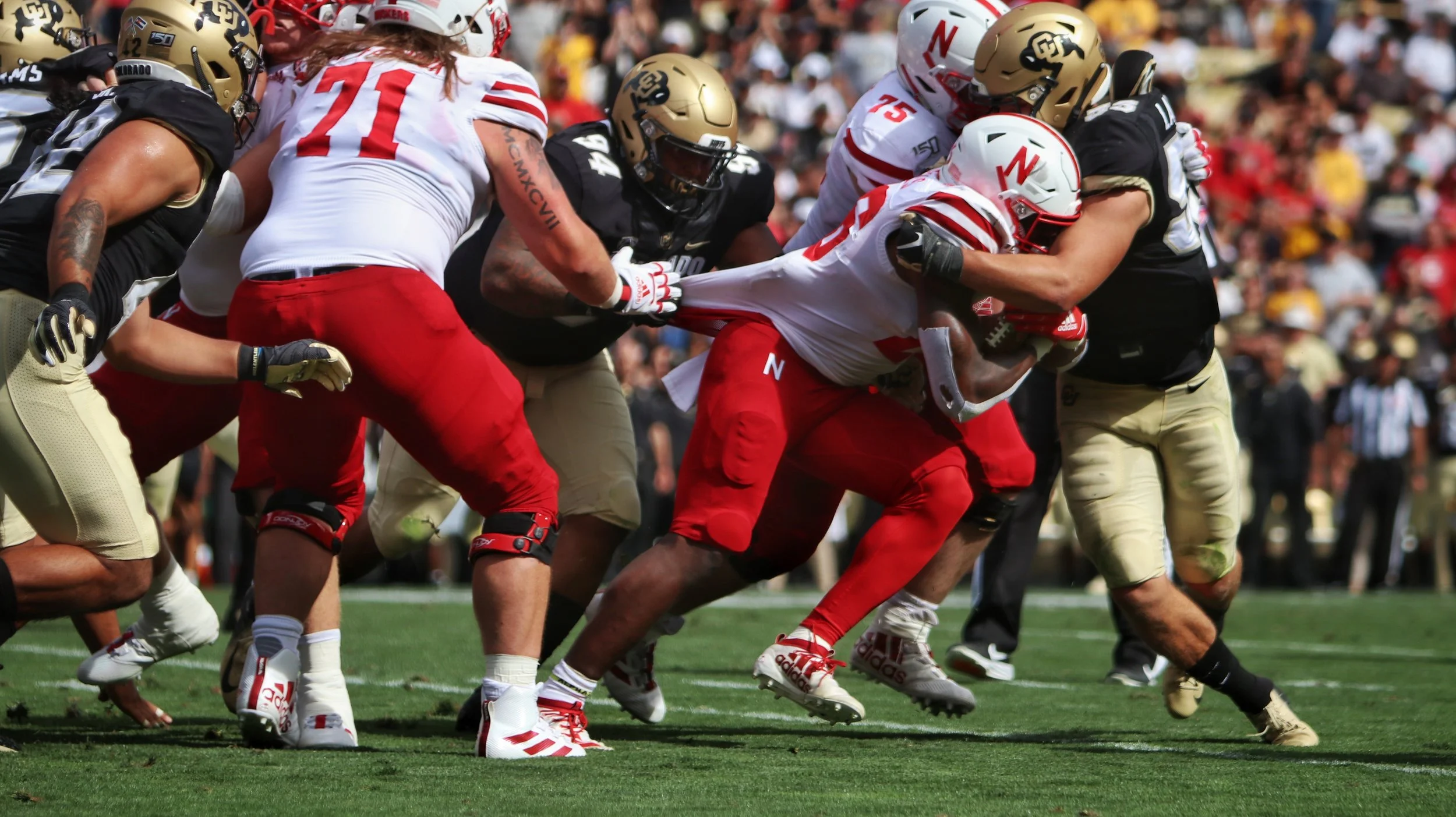 FootballPlayersHoldingTheBallAndTackling.jpg