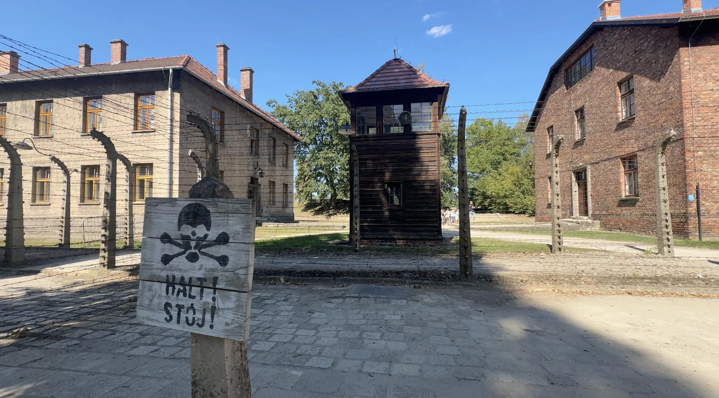 Brick barracks, barbed-wire fencing and a guard tower at Auschwitz I in Poland