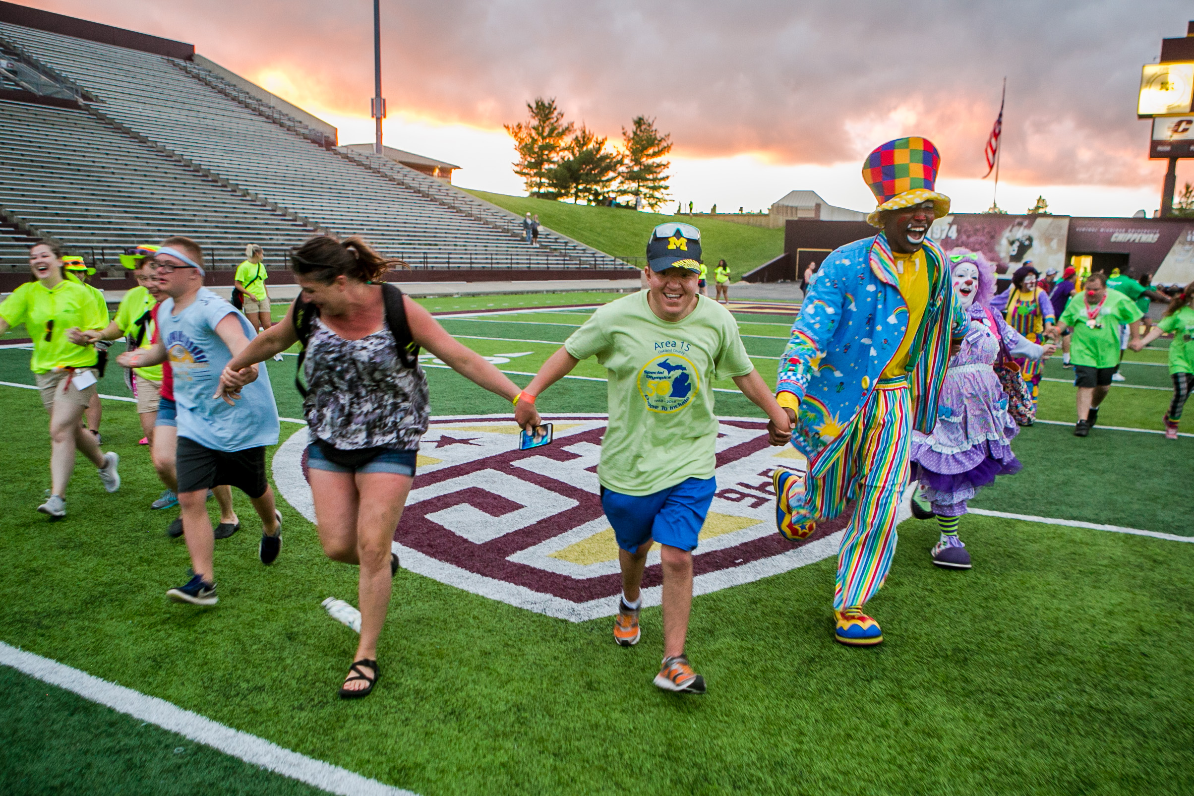 Athletes, volunteers, chaperones and the Mott Campus Clowns from Mott Community College join hands and run to the center of the football field at Kelly/Shorts Stadium after the Closing Ceremony of the 2018 Special Olympics of Michigan on Friday, May 31, 2018 in Mount Pleasant, Mich.