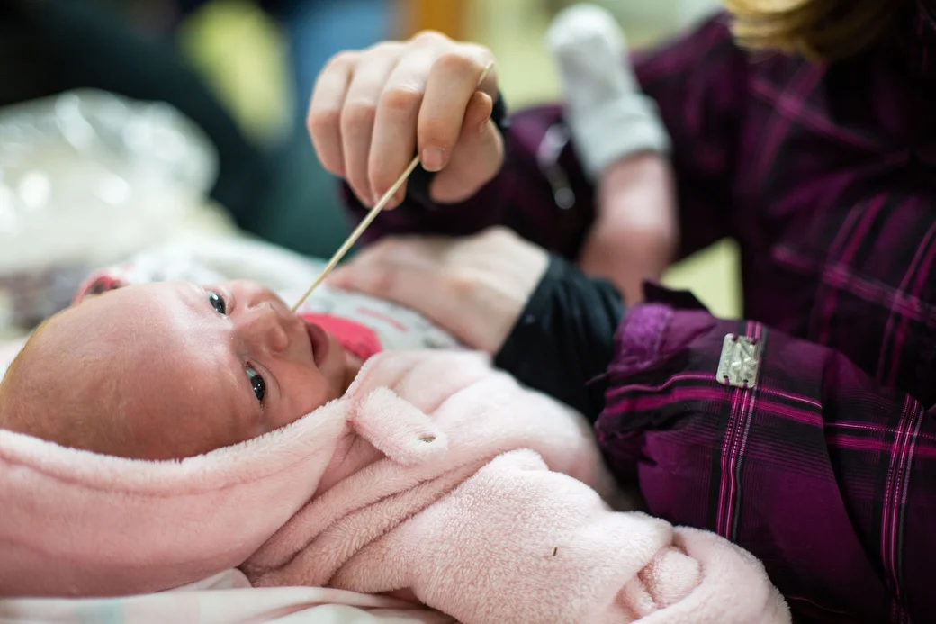  Ivy spreads medicine onto Christina's tongue, Tuesday, Nov. 13, 2018 at the Isabella Community Soup Kitchen. Christina has thrush and bronchiolitis. "I feel like a bad parent," Kemp said. "She's not even a month old and she's homeless." 