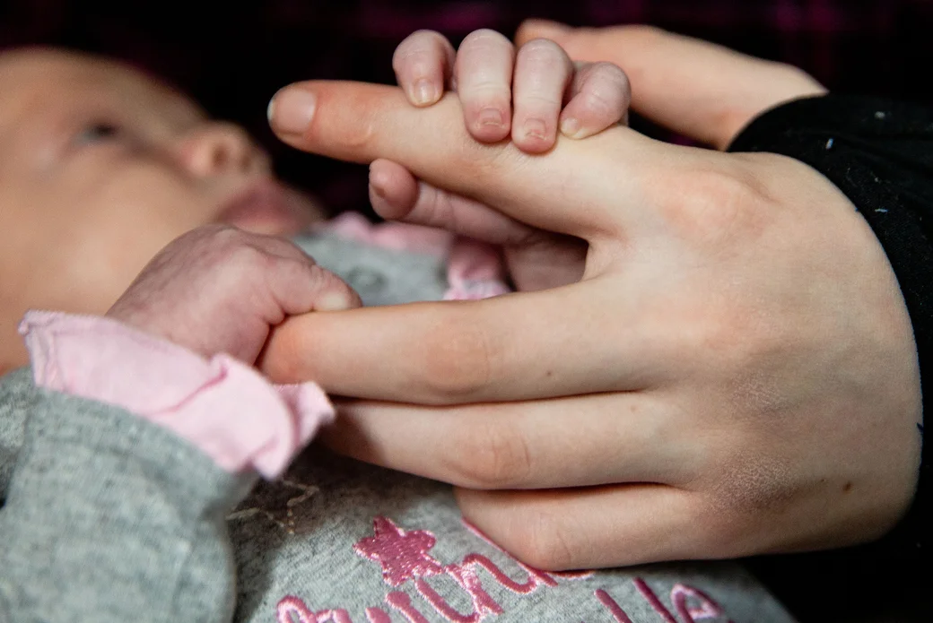  Christina grasps onto Ivy's hand, Wednesday, Nov. 21, 2018 in their motel room. Ivy's favorite time is when Christina is awake because she gets to interact with her. She's excited for Christina to get a little older and be able to play more. 