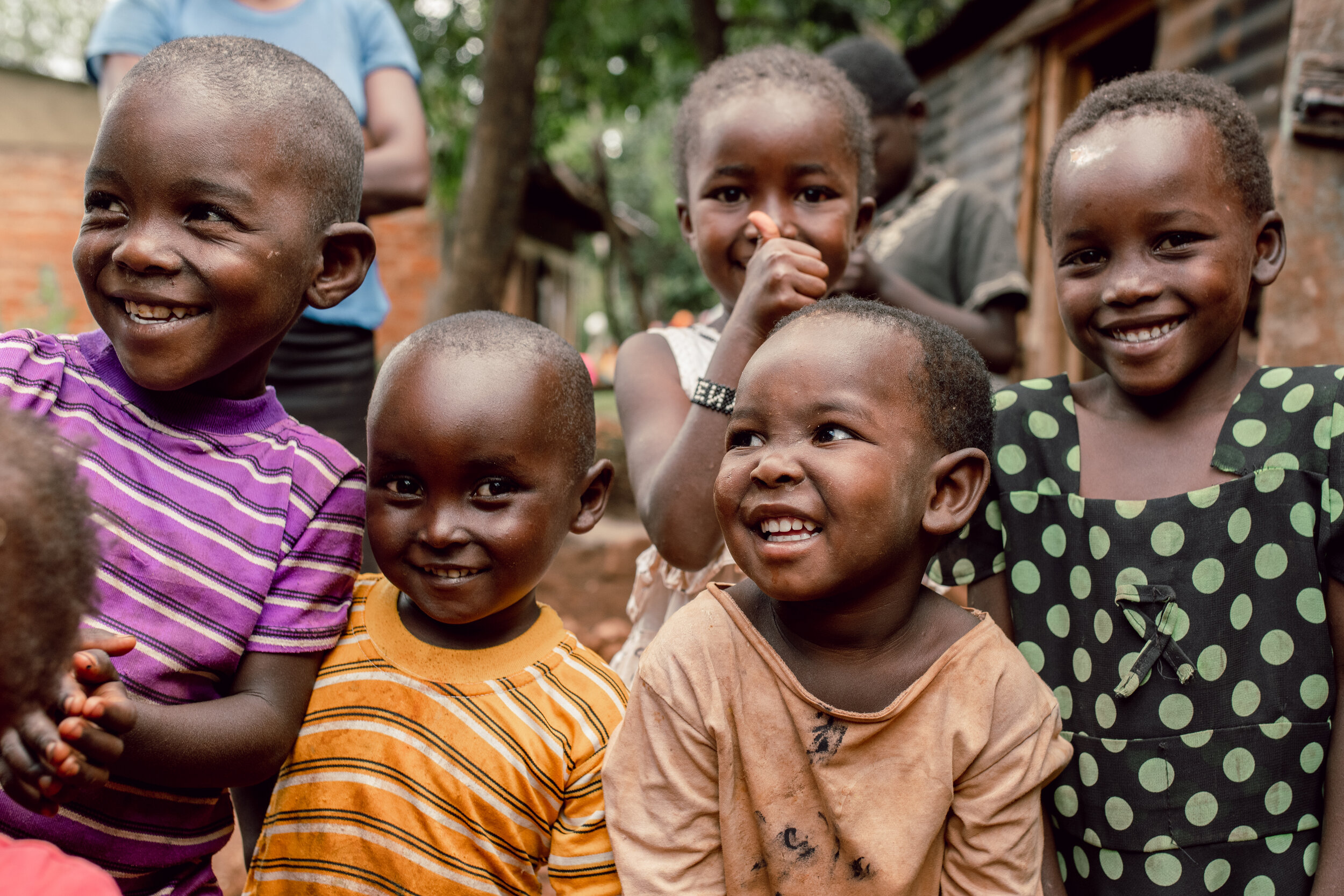 A group of children gather around as they take a break from playing. Kebabe, Kisii, Kenya