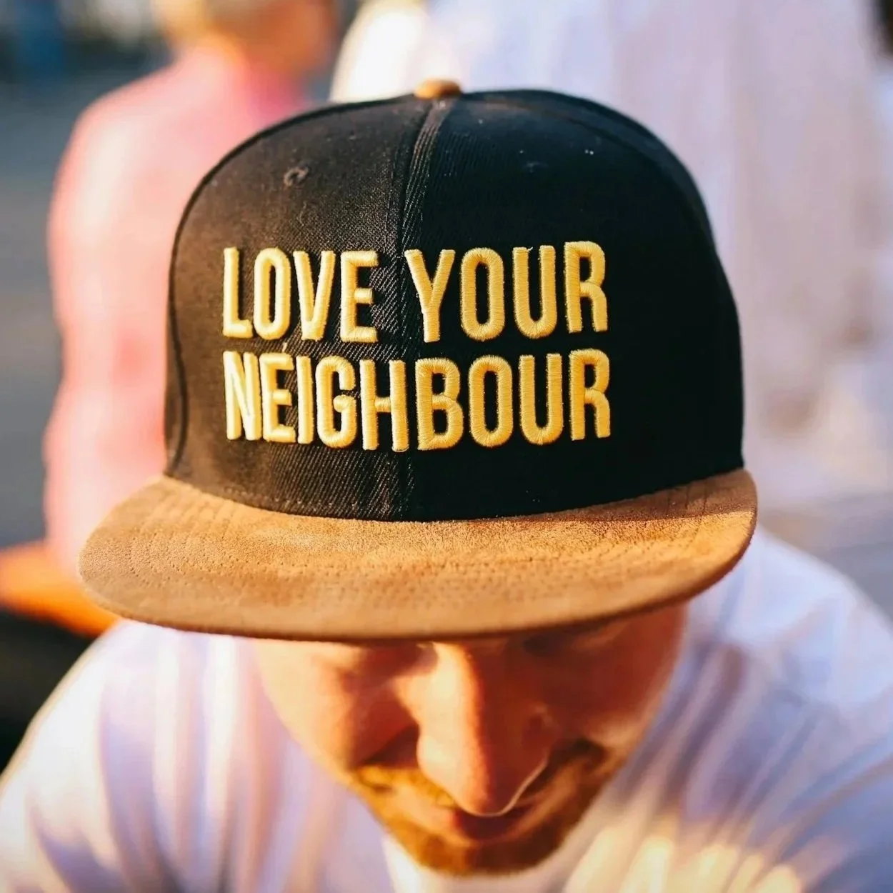 Man with Love Your Neighbor trucker hat