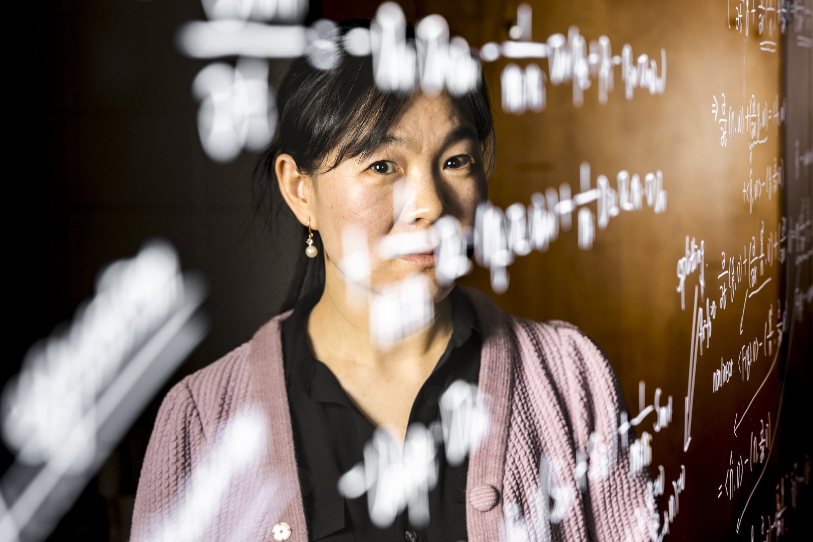 Lin Mu, leading researcher in the area of Applied Mathematics, poses for a portrait in front of an equation at her office at the Boyd Graduate Research Center in Athens, Ga., on February 7, 2023.