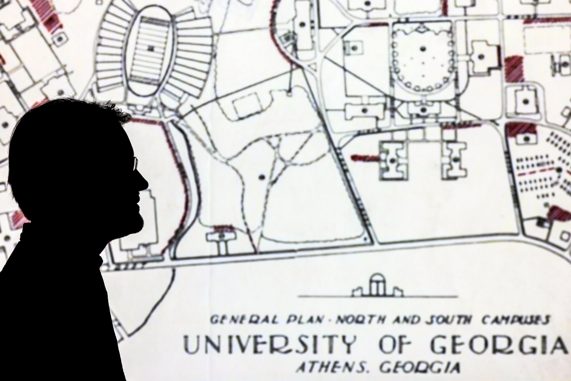 Steven Armour, University Archivist, poses for a portrait in front of historic campus plans at the Special Collections Library in Athens, Ga., on October 26, 2022.
