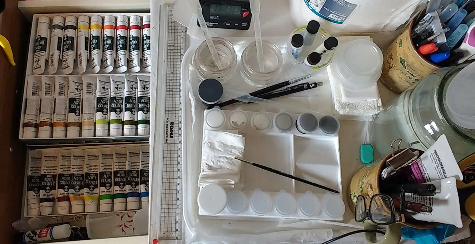 Image description; a selection of paining equiptment laid out on a worktop