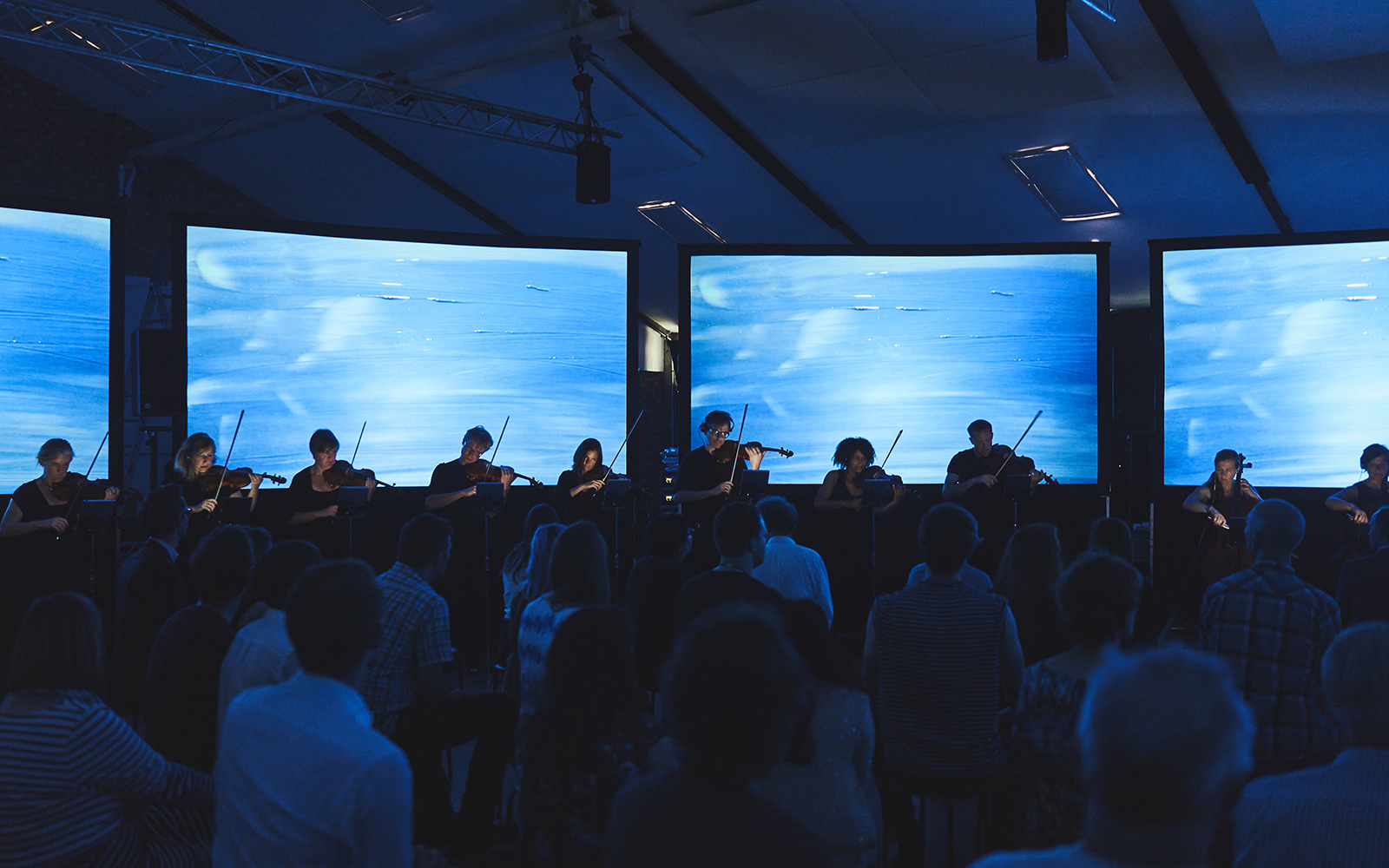 MICROSITE BANNER Performance with audience and blue watercolour screens.jpg