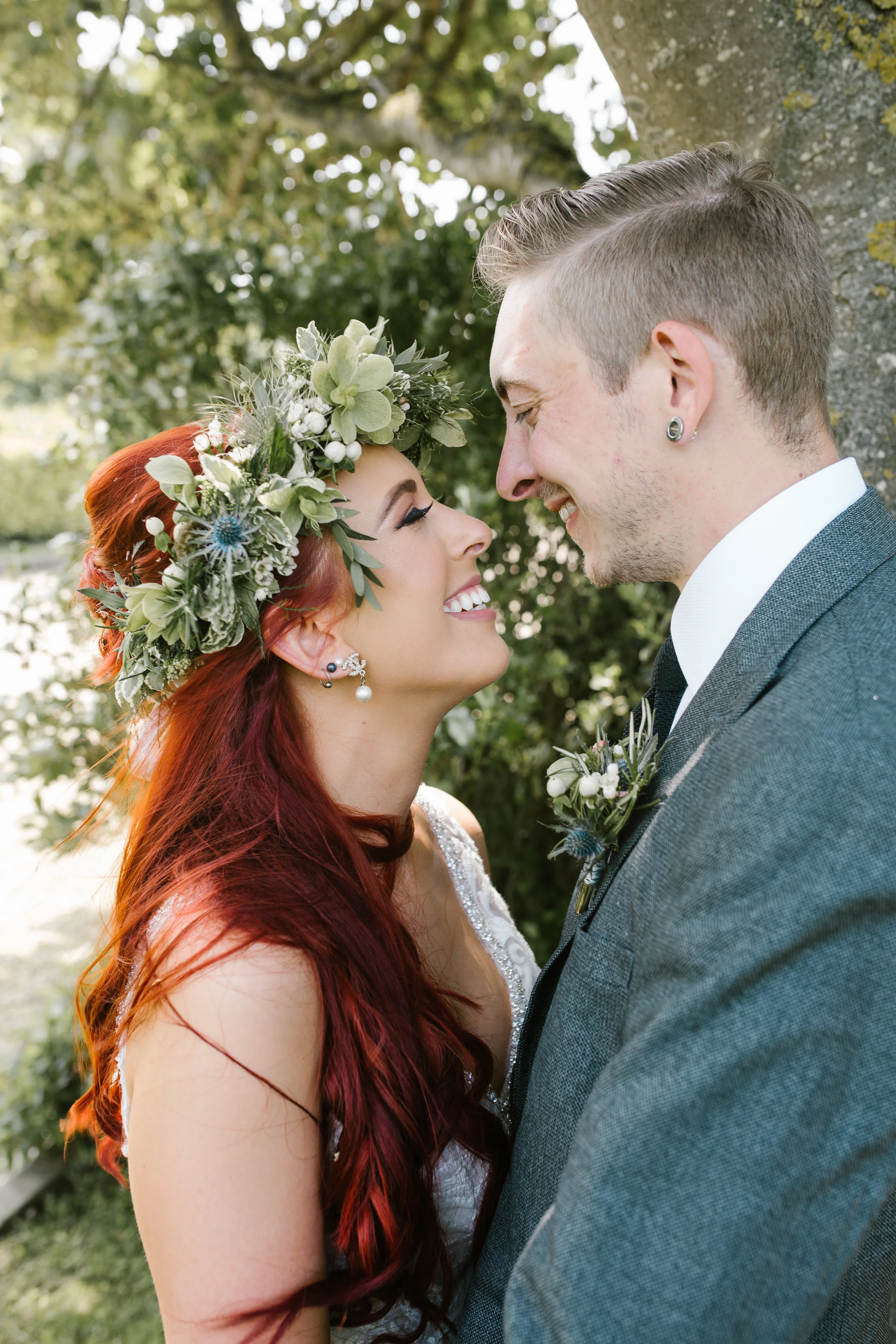 newlyweds smiling at one another, bride is wearing the most amazing flower crown