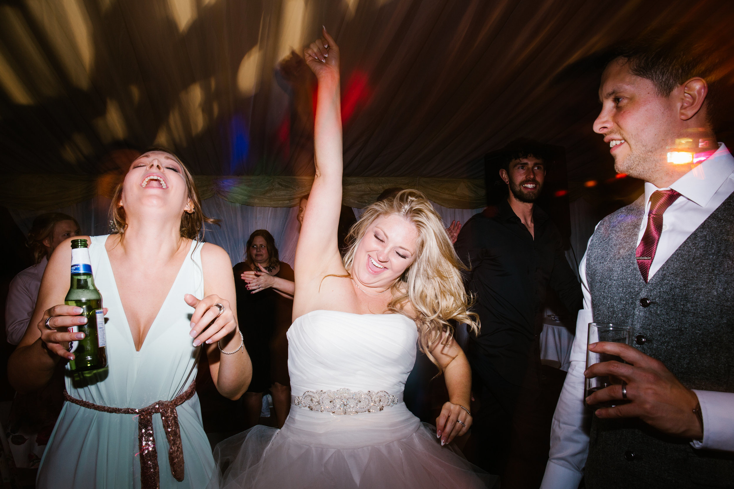 bride on the dance floor, dancing to the live band, having an epic time with her arms in the air- wedding photography in staffordshire