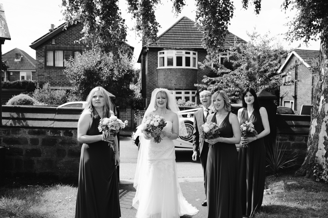 natural black and white photo of bride, father of the bride and bridesmaids arriving at the church - nottingham wedding 